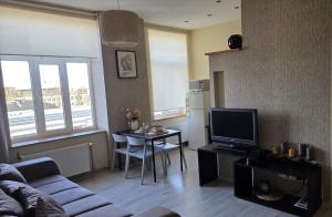 a living room with a couch and a table with a television at Center apartment Great Amber in Liepāja