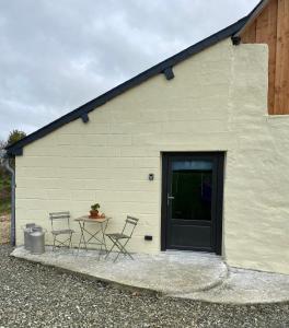 a building with a table and chairs next to a door at La Criberie in Saint-Ellier-du-Maine