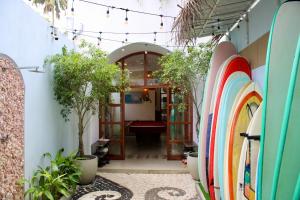 a hallway with surfboards and potted plants at Riptide Surfhouse in Weligama +6 photos
