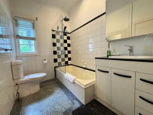 Cosy Cottage 4173 في بريزبين: حمام مع حوض وحوض استحمام ومرحاض +30 صورة