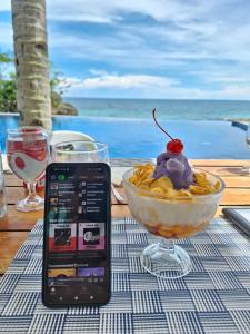 GuindulmanにあるDENTRISTOD Vacation Rentalのデザートのボウルが置かれたテーブルの上に置かれた携帯電話