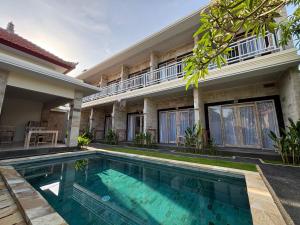 a house with a swimming pool in front of it at Casa Benoa Homestay in Nusa Dua