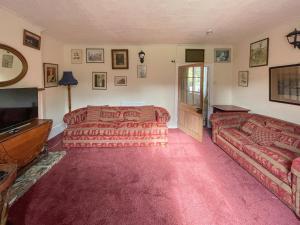 een slaapkamer met een bed, een bank en een televisie bij Duvale Priory - 9985 in Bampton