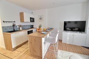 a kitchen with a table and a television in it at Le Logis Saint-Ursin by PRIMO C0NCIERGERIE in Bourges