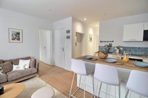 a kitchen and living room with a couch and a table at Le Logis Saint-Ursin by PRIMO C0NCIERGERIE in Bourges