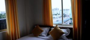 Cama con almohadas en habitación con ventana en Rajdhani Hospitality, en Kazhakuttam 32 fotos más