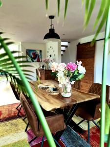 einen Holztisch mit Blumen im Wohnzimmer in der Unterkunft Dukes View -explore Haspengouw & surrounding towns in Zoutleeuw