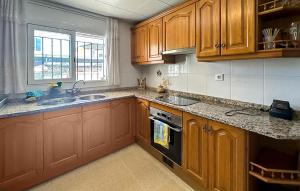 a kitchen with wooden cabinets and a sink at 4 Bedroom Lovely Home In Creixell in Roda de Bará