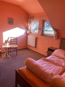 - une chambre avec des murs orange, un lit et une table dans l'établissement Penzion D'Artagnan, à Kořenov 18 autres photos