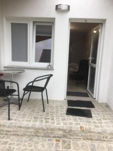 KrobicaにあるPokoje przy strumyczkuのパティオ(椅子、テーブル、窓付)