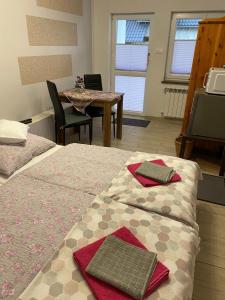 KrobicaにあるPokoje przy strumyczkuのベッド2台、テーブル、テレビが備わる客室です。