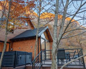 a house with a balcony with a table and chairs at Boga Chalet in Bogë