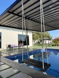 a patio with a swing and a swimming pool at Lamour Villa in Şallān