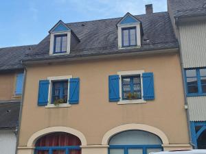 a house with blue shutters and two windows at logement moderne in Campan +2 photos