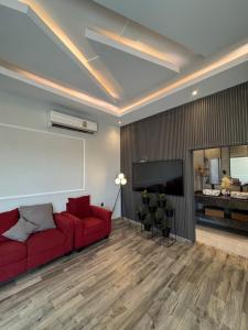 a living room with a red couch and a flat screen tv at Lamour Villa in Şallān