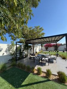 a patio with a table and chairs under a canopy at Lamour Villa in Şallān