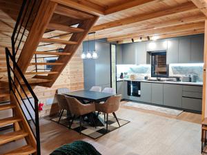 a kitchen and dining room with a table and chairs at Boga Chalet in Bogë