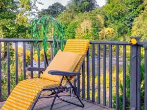 a chair sitting on a deck with a fence at The Hive in Hawick +6 photos