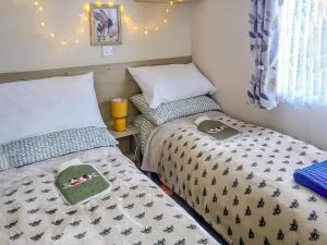 a small room with two beds and a window at The Hive in Hawick