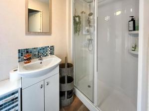 a white bathroom with a shower and a sink at The Hive in Hawick