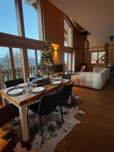 a living room with a table with a christmas tree at Chalet Asphodel in Plan Fey