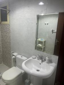 a bathroom with a sink and a toilet and a mirror at comfort private master room in Sharjah