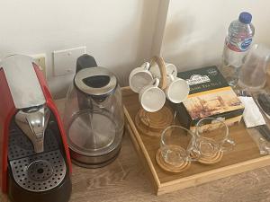 a table with cups and a blender and a book at comfort private master room in Sharjah +12 photos
