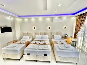 a bedroom with three beds and a large window at Hagia Sophia Palace Hotel in Istanbul