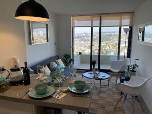 einen Esstisch mit Tellern und Weingläsern darauf in der Unterkunft Departamento con vista a las Dunas y playa in Concón