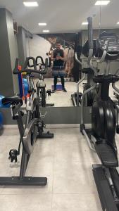 Ein Mann steht in einem Fitnessstudio mit mehreren Cardiogeräten. in der Unterkunft Departamento con vista a las Dunas y playa in Concón