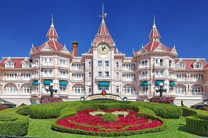 a large building with a clock tower and a garden at Le Familial - Disneyland, parking gratuit in Montry