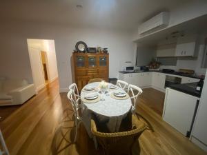 eine Küche mit einem Tisch mit Stühlen und einer Uhr in der Unterkunft Newport Cottage sleeps 5 in Newport + 65 Fotos