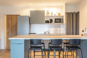 eine Küche mit einer Theke mit Stühlen drum herum in der Unterkunft Flowers in Rochefort