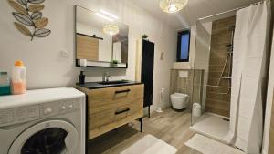 a bathroom with a washing machine and a shower at Studio cosy au calme , Boé in Boé