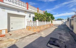a house with a garage door and a fence at 2 Bedroom Beautiful Home In Benalmadena in Benalmadena Costa +10 photos