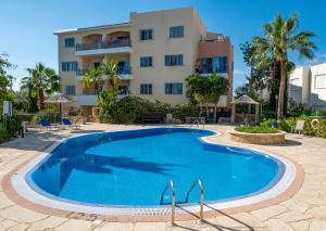 a swimming pool in front of a building at Hermes Gardens in Paphos