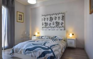 ein Schlafzimmer mit einem Bett mit einer blau-weißen Bettdecke in der Unterkunft Amazing Apartment In Trappitello in Trappitello