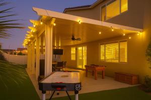 a patio with a ping pong table and lights at Windridge Manor - Wine Country Retreat with 6 Beds, Garden, Pool, Games & BBQ in Winchester