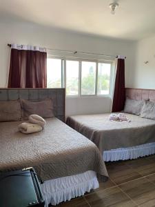 Un dormitorio con dos camas y una ventana en Pousada Ap, en Acaraú