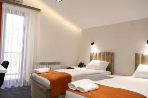 a hotel room with two beds and a window at New Casa Boutique Hotel in Yerevan