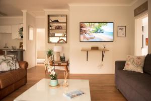 ヘルマナスにあるCalTye On Seaのリビングルーム(ソファ、壁掛けテレビ付)