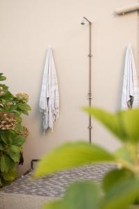 ヘルマナスにあるCalTye On Seaのタオル2枚が壁に掛かっている