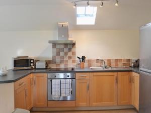 una cucina con fornelli e lavello di Bluebell Cottage ad Alburgh