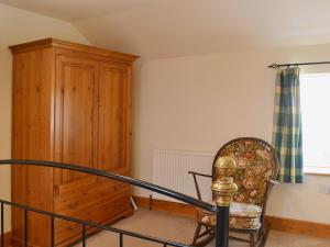 una camera con armadio in legno e sedia di Bluebell Cottage ad Alburgh Altre 3 foto