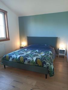 ein Schlafzimmer mit einem Bett mit einer blauen Bettdecke in der Unterkunft Maison de vacances Ile d'Oléron 2 Chambres in Saint-Pierre-dʼOléron