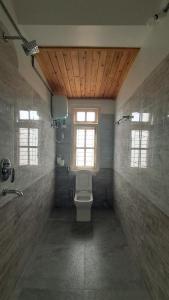 a bathroom with a toilet and a window at Red Cherry Homestay in Lava