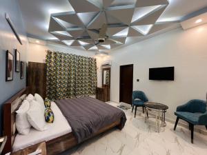 a bedroom with a bed and a ceiling fan at Karachi Inn PECHS in Karachi