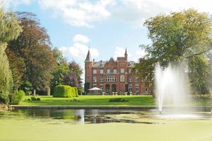 una fontana nel mezzo di un laghetto di fronte a un edificio di Hotel Lodewijk Van Male a Bruges
