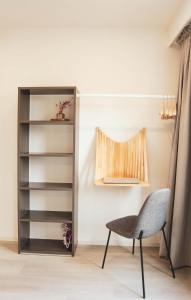 Una silla y un estante para libros en una habitación. en Apartment at the station of Torhout, en Torhout