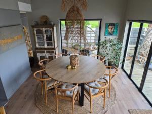 ein Esszimmer mit einem Holztisch und Stühlen in der Unterkunft The Compass in Marina da Gama